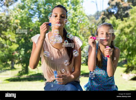 Feliz Madre E Hija Soplando Burbujas Fotografía De Stock Alamy