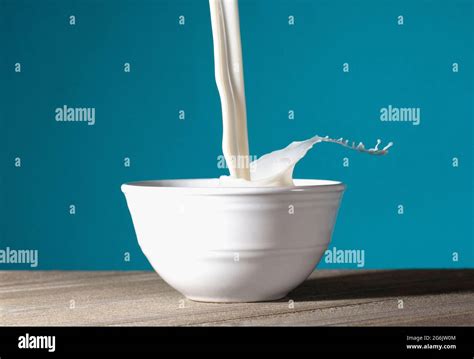 A Bowl Of Milk Being Poured And Splashing Out Stock Photo Alamy