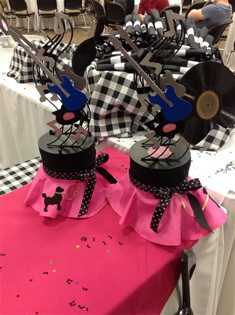 Two Black And White Checkered Tables With Pink Tablecloths Scissors