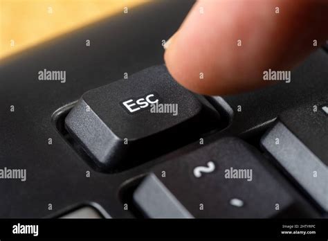 Man Pressing The Escape Key On A Simple Black Office Keyboard Finger