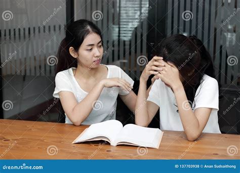 Young Asian Woman Comforting Her Depressed Friend In Living Room Stock