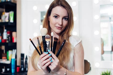 Portrait Of Female Beautician Holding A Set Of Makeup Brushes In Beauty