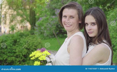 meeting daughter and her mother in the park attractive brunette is hugging her mom with love