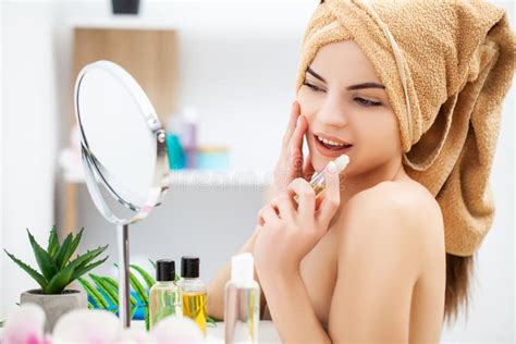 Woman Getting Ready For Work Doing Morning Makeup In Bathroom Mirror At Home Stock Image