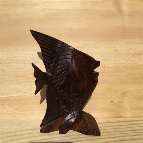 A Wooden Sculpture Of A Fish On A Wood Surface