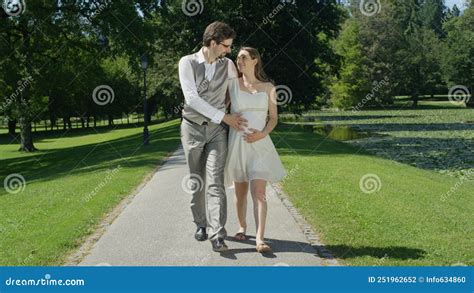 Happy Young Couple Gaze At Each Other While Gently Stroking Her