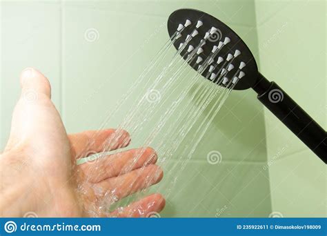 The Palm Touches The Water Under The Shower Black Watering Can Stock