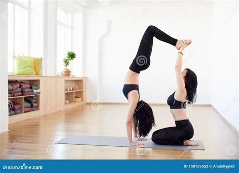 Partner Yoga Side View Of Flexible Women Helping Each Other Practicing