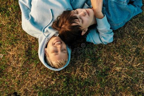 top view of happy lesbian couple lying on the grass in summer park women in love dreaming