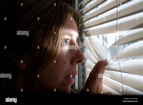 Woman Peeking Out Blinds Stock Photo Alamy
