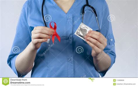 Gynecologist Holding Red Ribbon And Condom Aids Awareness Warning
