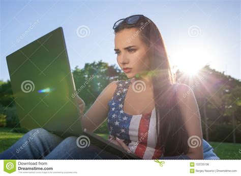 Pretty Young Woman Sitting On Bean Bag Use Laptop While Resting On