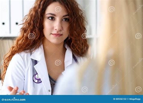 Beau Portrait Femelle De Docteur Dans Le Bureau Avec Le Visiteur Photo