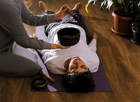 Woman Making Relaxing Massage For Young Man Meditation Sound Therapy With Tibetan Singing