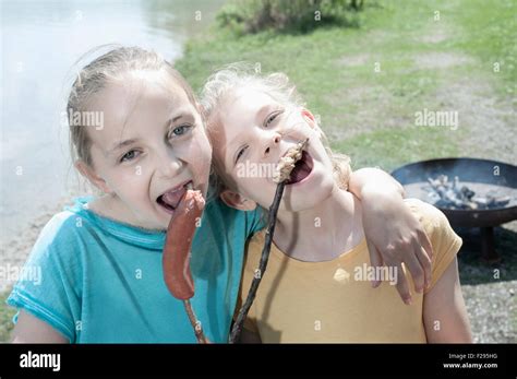 Two Friends Eating Sausage And Bread At Lakeshore Bavaria Germany