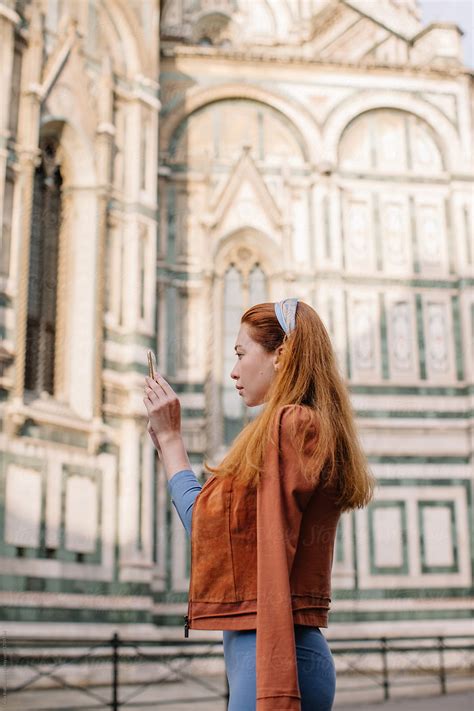 Side View Portrait Of Redhead Girl Taking Picture Of Duomo In Florence Del Colaborador De