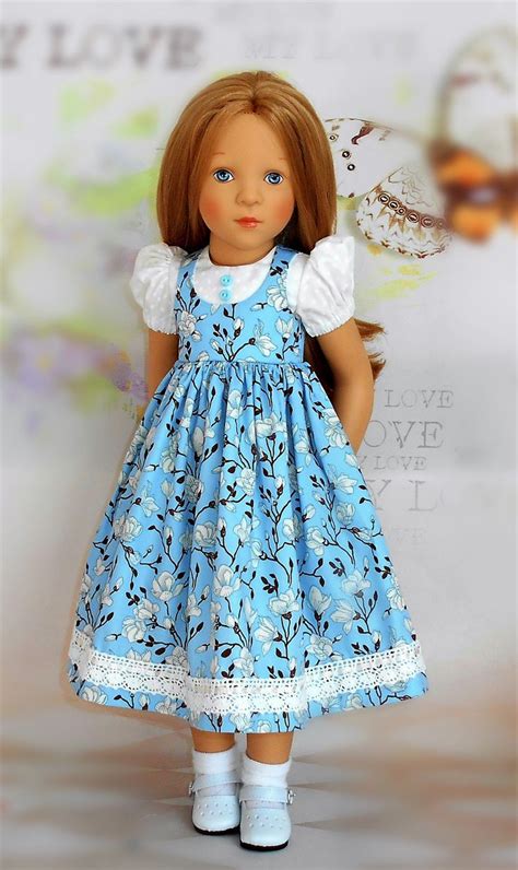The Doll Is Wearing A Blue Dress And White Shoes