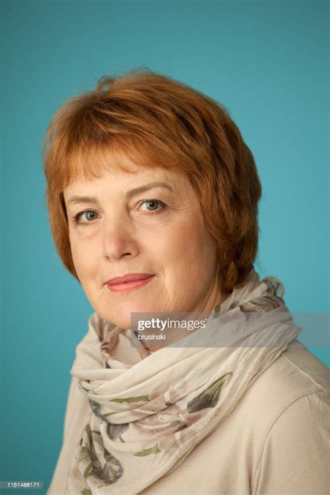 Studio Portrait Of An Attractive 60 Year Old Woman On A Blue Background