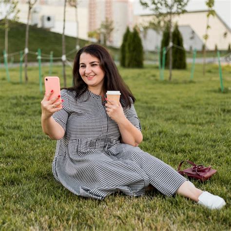 Free Photo Smiley Brunette Woman Taking A Selfie While Holding Her Phone
