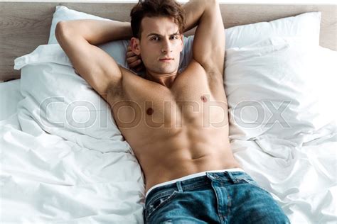 Sexy Man In Denim Jeans Lying On Bed At Stock Image Colourbox