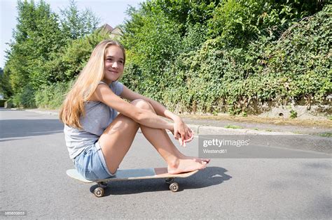Blond Teenage Girl Sitting On Skateboard Photo Getty Images