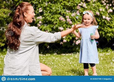 Mother With Daughter Blowing Soap Bubbles At Park Stock Image Image