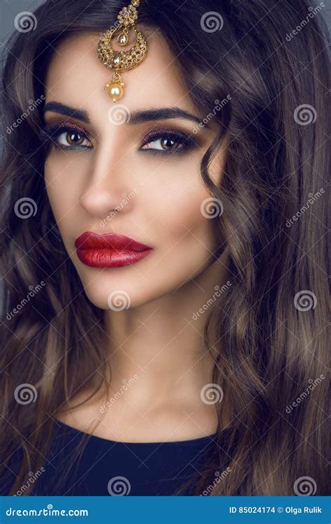 portrait de jeune brune magnifique avec de longs cheveux et maquillage provocateur utilisant les