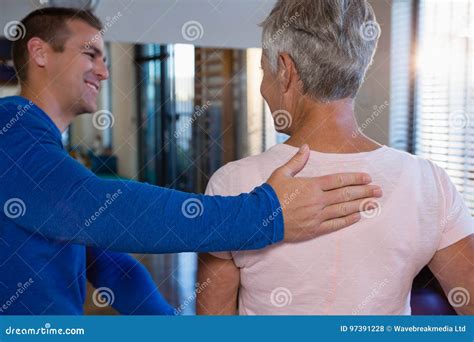 Physiotherapist Giving Back Massage To Female Patient Stock Photo