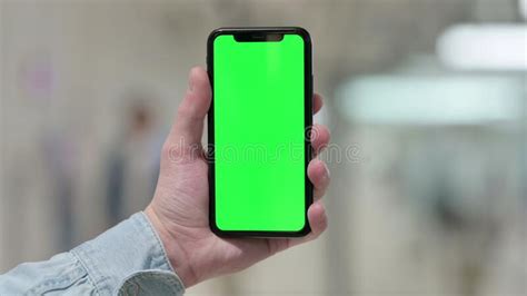 Close Up Of Hand Holding Smartphone With Green Screen Stock Photo
