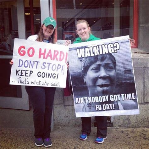 Two Women Holding Up Signs In Front Of A Building That Says Go Hard Don