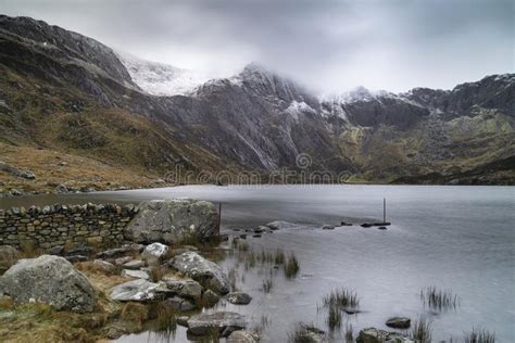 Beautiful Moody Winter Landscape Image Of Llyn Idwal And Snowcapped