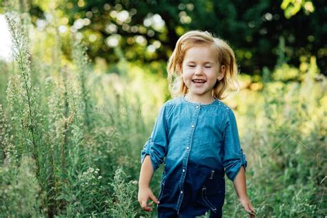 Close Up Portrait Of Happy Cute Little Girl In Field Of Wildflowers