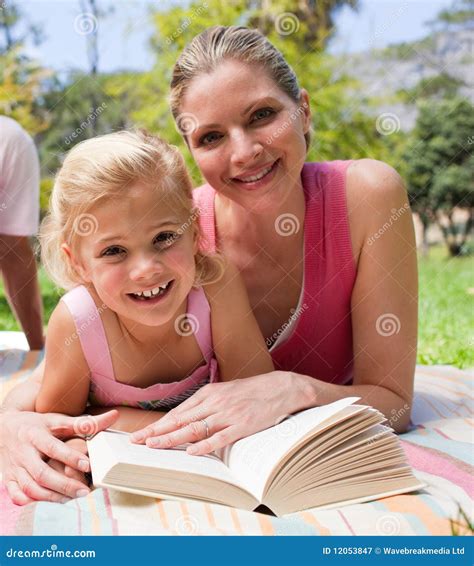 Happy Mother And Her Daughter Reading In A Park Stock Image Image Of