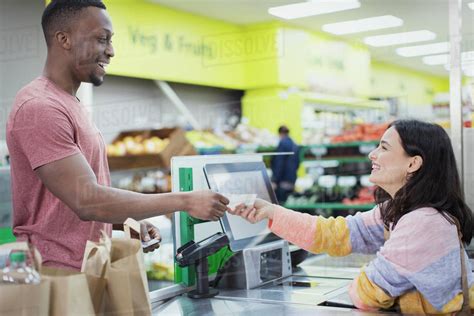 Cashier Giving Receipt To Customer At Supermarket Checkout Stock