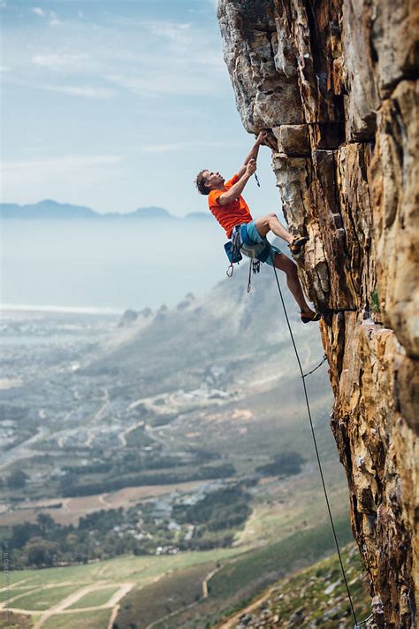 Mountain Climber Climbing A Mountain Cliff By Stocksy Contributor