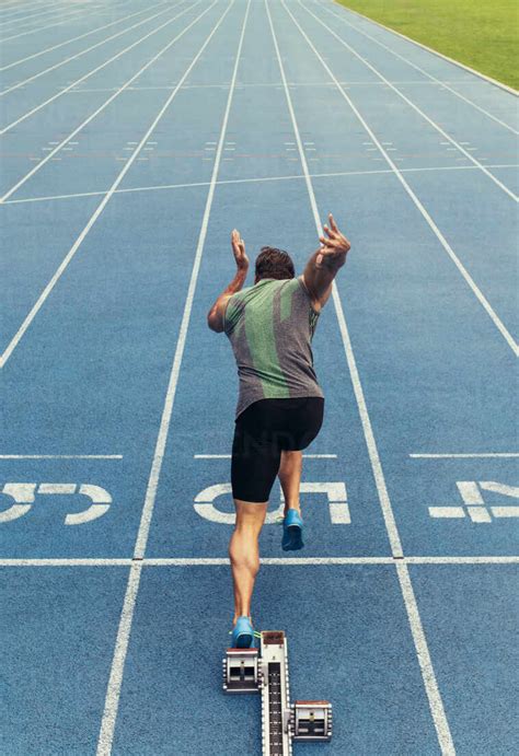 Rear View Of An Athlete Starting His Sprint On An All Weather Running