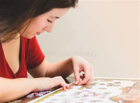 Woman Trying To Match Pieces Of A Jigsaw Puzzle Game Stock Image