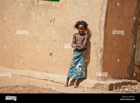 A Fulani Girl Stands Against A Mud House In The Town Of Djibo In