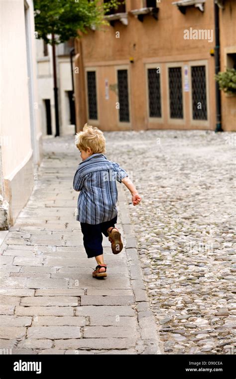 A Very Young Boy Running Away From The Photographer Stock Photo Alamy