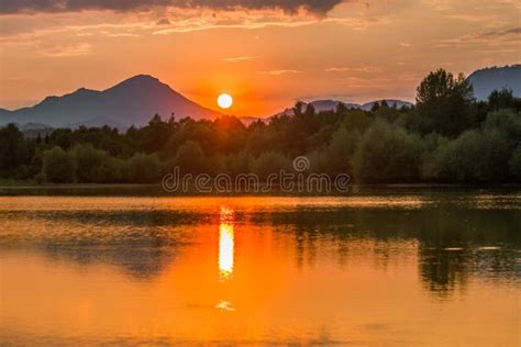 A Beautiful Colorful Sunset Landscape With Lake Mountain And Forest