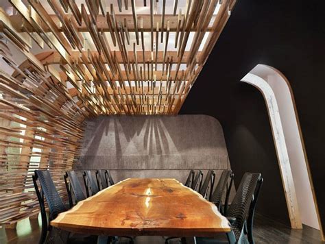 A Wooden Table With Chairs Around It In Front Of A Wall Made Out Of
