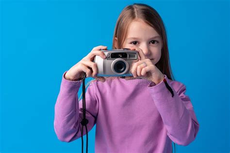 Portrait Of A Little Girl With Camera Against Blue Background Stock
