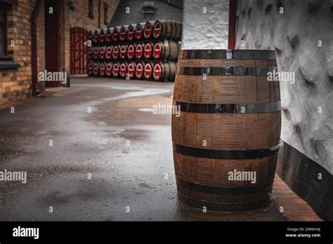 Wooden Whiskey Barrel In An Alley With Rows Of Barrels In Background