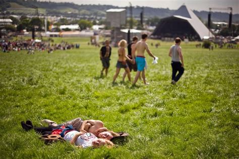 A Couple Soaked Up The Sun In The Grass At The Annual Glastonbury