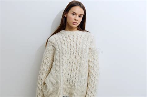 A Beautiful Attractive Woman In A White Autumn Warm Sweater Stands On