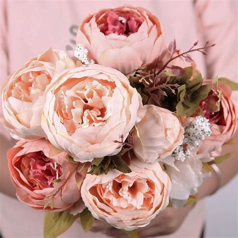 A Woman Holding A Bouquet Of Flowers In Her Hands