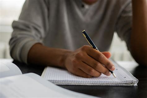 Crop Black Man Writing In Copybook · Free Stock Photo