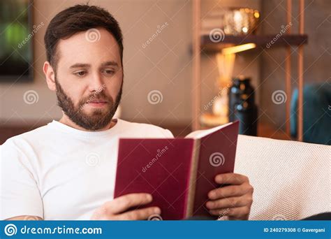 Man Reading Book And Sitting In Armchair At Home Stock Photo Image Of