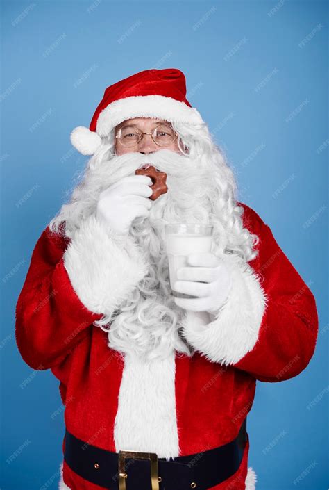 Free Photo Hungry Santa Claus Eating Cookie At Studio Shot