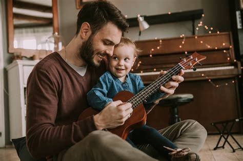 Padre Enseñando A La Hija A Tocar La Guitarra En La Habitación De Su